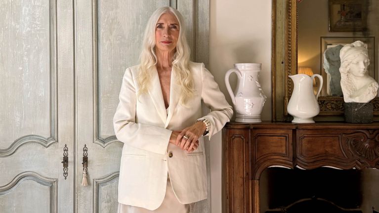 Ceramist Trudy Crane wearing a white blazer and white pants for an article about her monochrome holiday style.