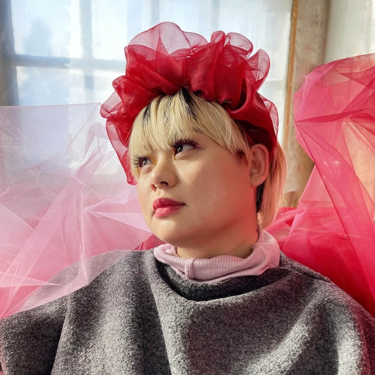 Photo of a woman wearing a red organza headband.