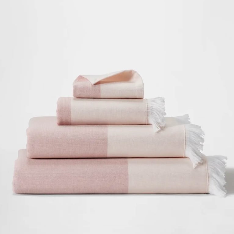 A photo of a stack of four pink and cream coloured towels.