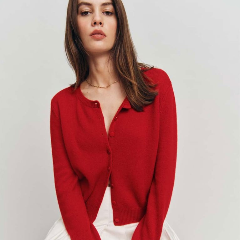 A model wearing a red cashmere cardigan from Reformation for an article about the best fashion trends of 2026.