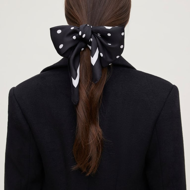 A model wearing a black and white polka dot satin scarf from Dynamite to illustrate the polka dot trend.