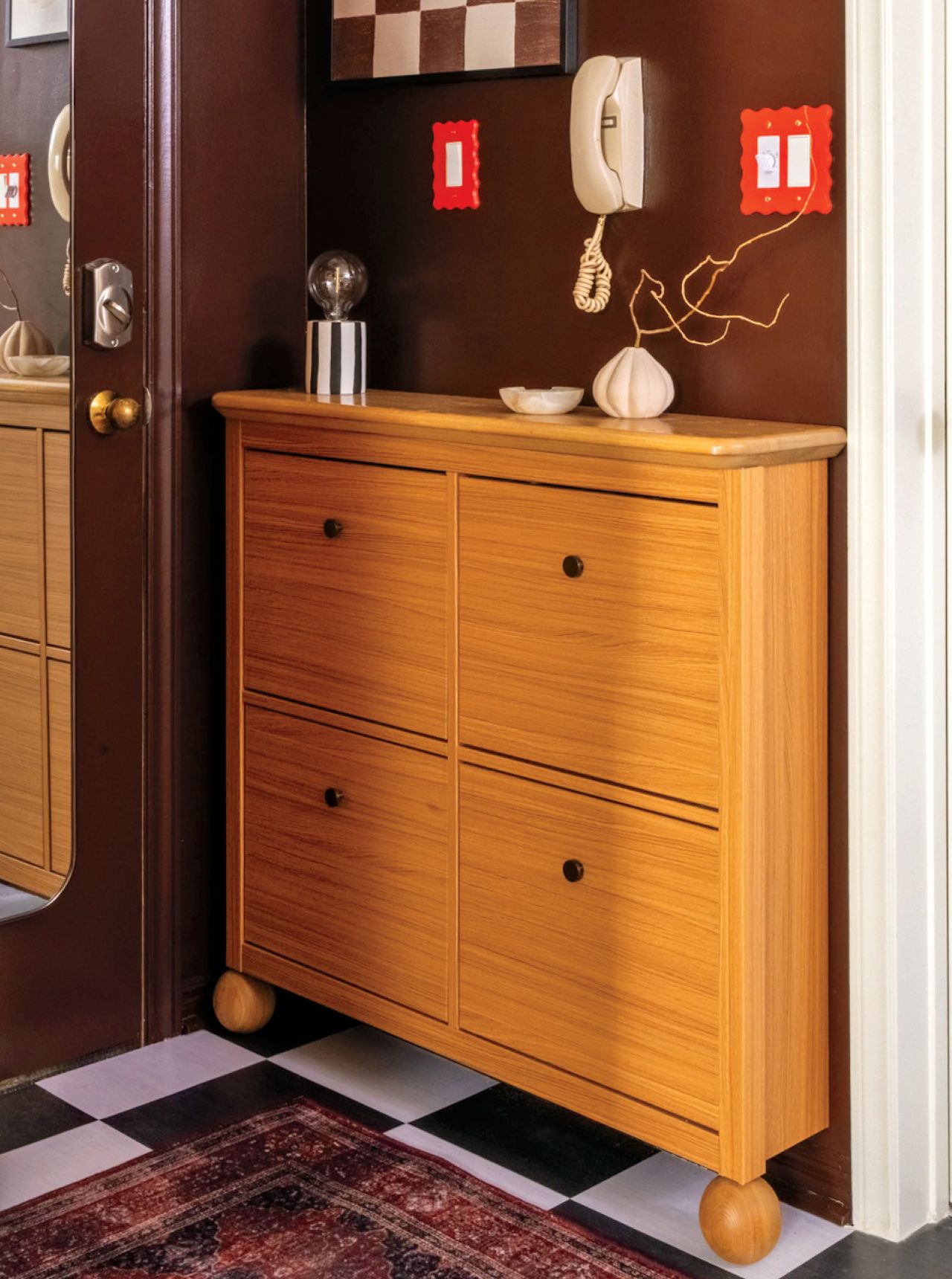 An IKEA storage unit with new rounded legs in a mid-century modern entryway by decor expert Alexandra Gater for an article about easy DIY home decor projects.