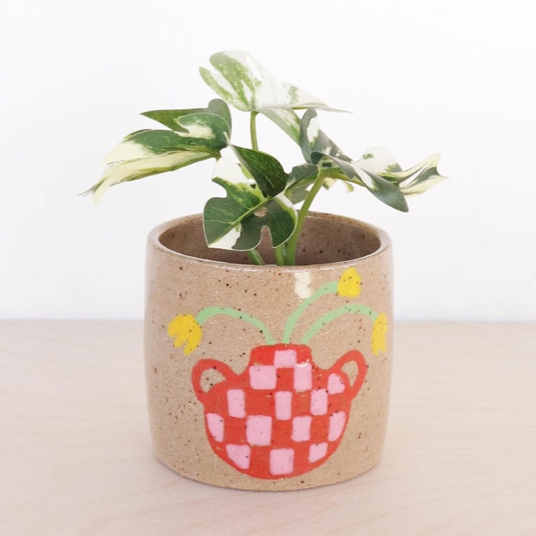 A ceramic planter with a flower design from Nightshift Ceramics for an article about Etsy breakup registry gifts.