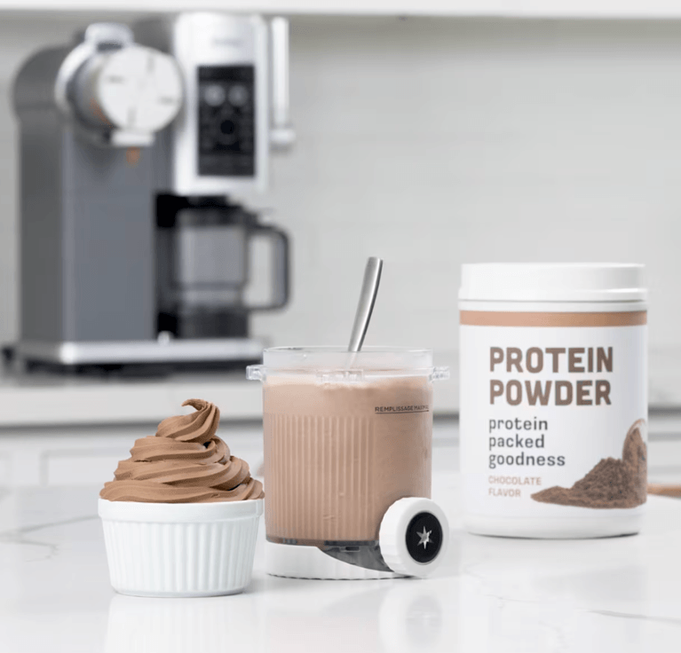 Protein powder container and ice cream with Ninja CREAMi machine in background