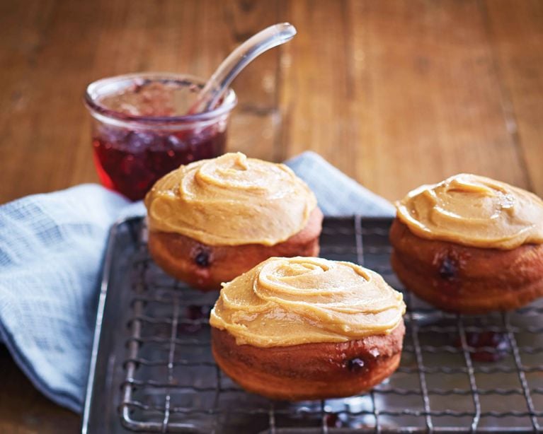 Homemade peanut butter and jelly doughnut with a thick peanut butter glaze and red grape jelly filling.