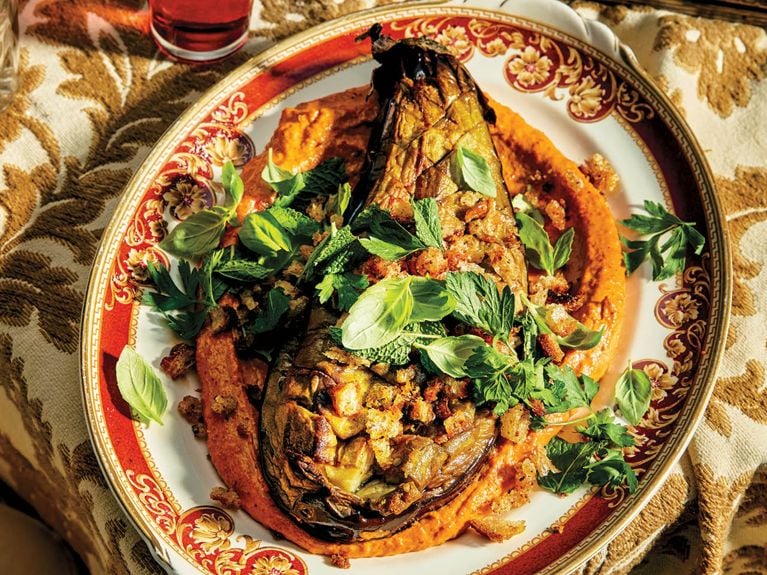 A roasted half eggplant topped with sesame romesco sauce,