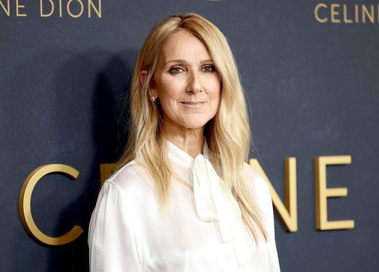 A photo of a woman with long blonde hair in a white blouse.