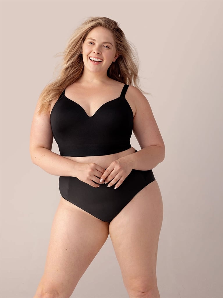 A model wearing a black Shapermint Truekind Supportive Comfort Wireless Shaping Bra for an article about comfortable bras for larger busts.