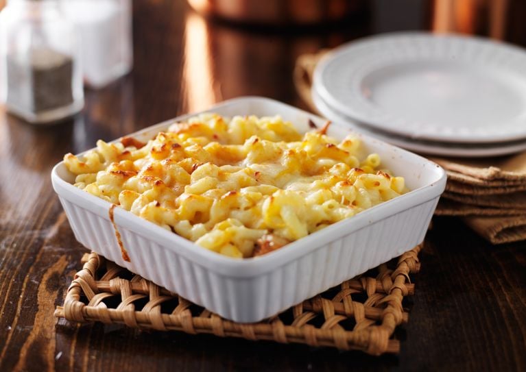 A square white dish full of macaroni and cheese.