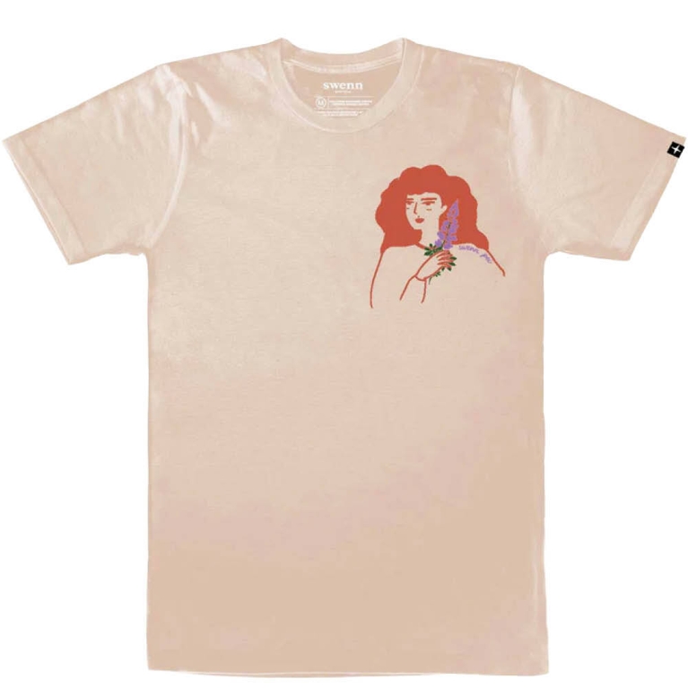 A beige t-shirt with an illustration of a redheaded woman holding a lupine sprig used in a post on what to do in Prince Edward Island