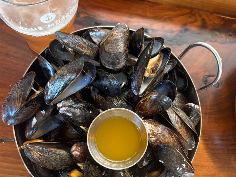 A bowl filled with mussels and a smaller bowl of melted butter for a post on what to do in Prince Edward Island