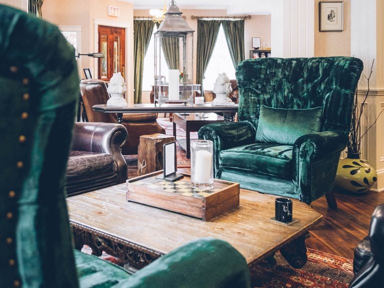 Two green velvet armchairs in the lobby of the Great George Hotel in Charlottetown in a post about what to do in Prince Edward Island