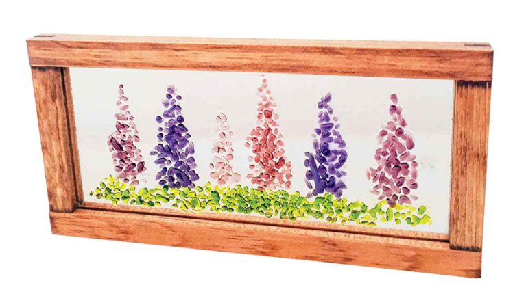 A pane of fused glass with a lupine design used in a post on what to do in prince edward island