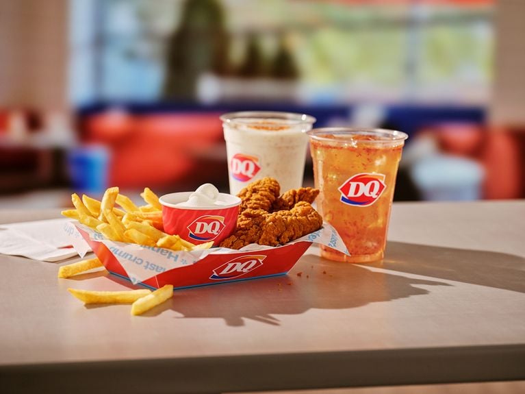A photo of a basket of Dairy Queen spicy chicken strips and fries next to a dipping container of soft serve in a post about DQ Swicy Menu.