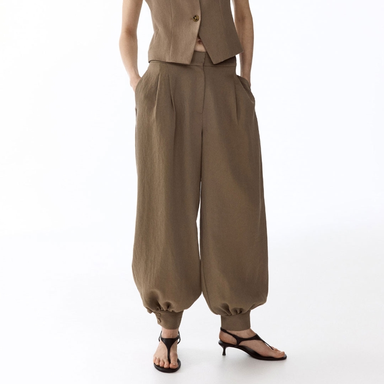 A model wearing beige H&M Balloon-Leg Twill Pants for an article about the balloon-hem pants trends.
