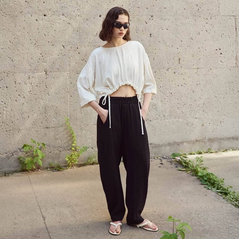 A model wearing the Eve Gravel Shepherd Pants in black for an article about the best purchases editors picked in April 2026