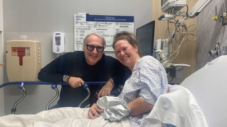 A man and a woman in a hospital room ahead of surgery, for a story about a Canadian woman travelling to the U.S. for endometriosis surgery.