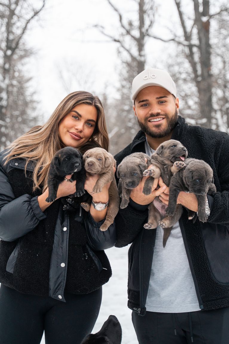A photo of a couple in the woods holding six puppies, used in a post about rescue dog show cbc.