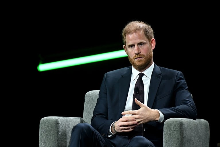A photo of a man in a suit grasping one hand with another in a post about Prince Harry lawsuit.