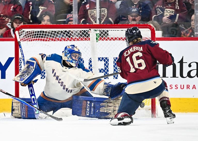 A photo of a pWHL player in a maroon jersey trying to score on a player in a white and blue jersey used in a post about PWHL salaries.