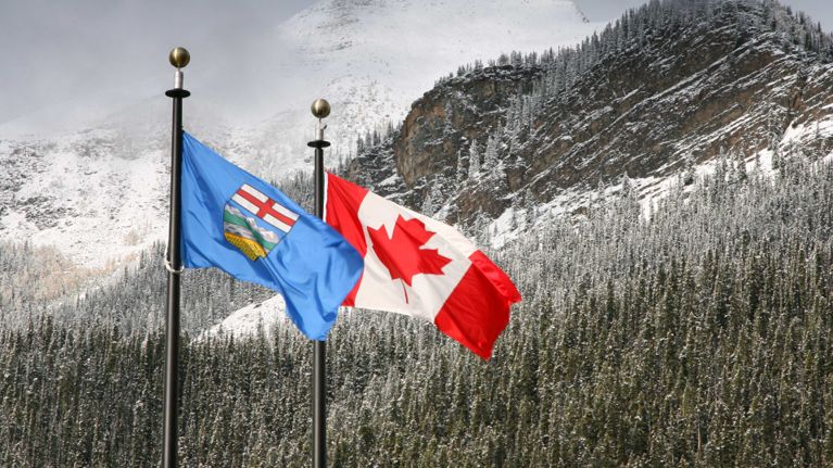 A photo of Alberta provincial and Canadian flags at Lake Louise, Alta., for a piece about the 2026 Alberta referendum.