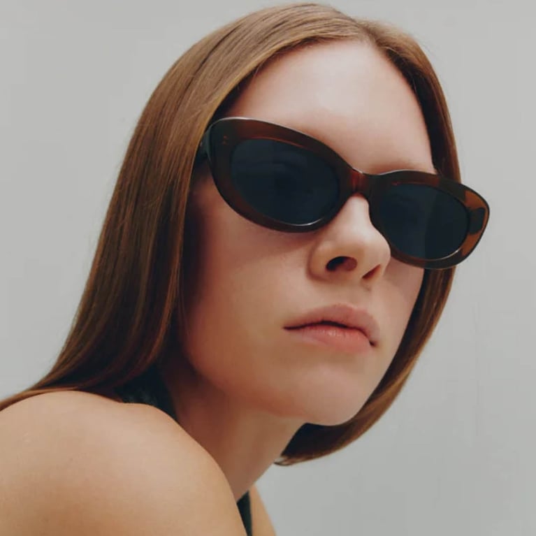 A model wearing Monos sunglasses for an article about the best purchases editors made in May 2026.