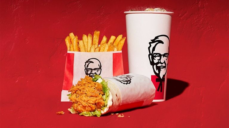 A KFC soft drink, fries and chicken snacker wrap on a red background in a post about $5 meal deals.