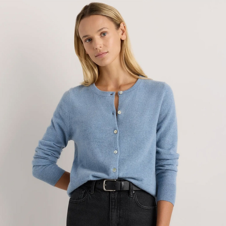 A model wearing a blue Quince Mongolian Cashmere Cardigan Sweater for an article about the best Mother's Day gifts.