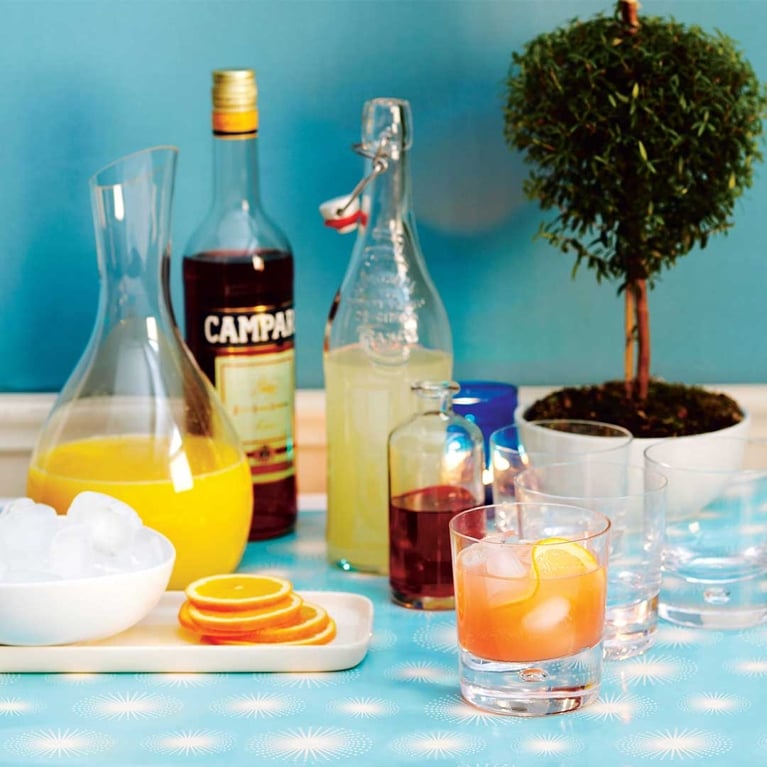 Bottles of lemonday, orange juice and campari used in a post on sparkling campari lemonade.