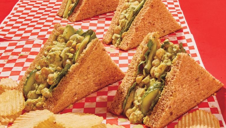 Triangle-cut sandwiches filled with spinach, cucumber slices, and smashed chickpea salad tossed in green goddess dressing.
