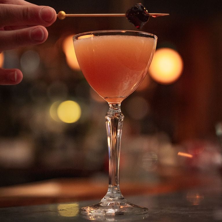 A coupe glass with a vodka-chai cocktail for a story on Heated Rivalry-themed drinks at Le Tambour Tavern.