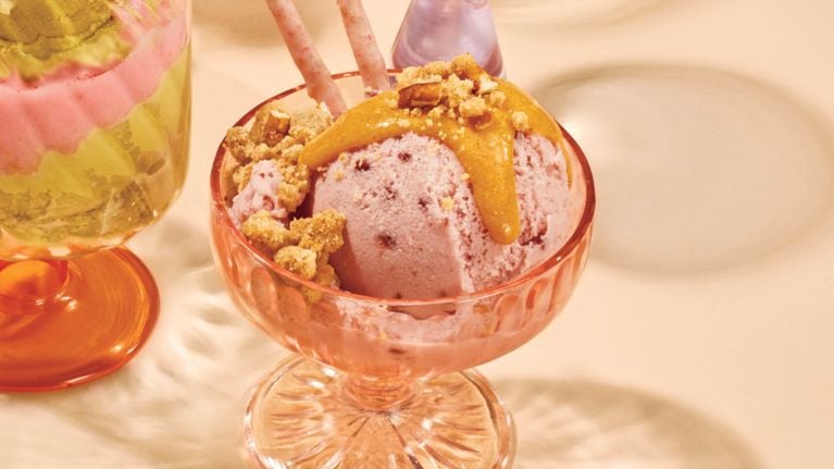 A bowl of ice cream drizzled in peanut brittle sauce.