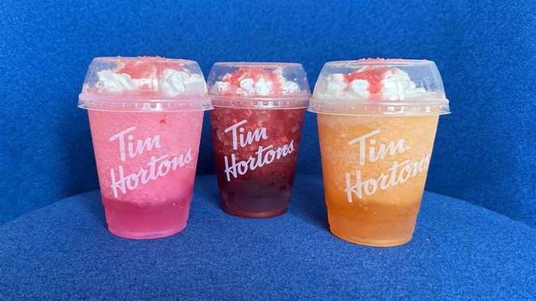 Three cups of Tim Hortons new Poppin' Frozen Quenchers in Strawberry Watermelon, Blackberry Yuzu and Orange Tangerine.